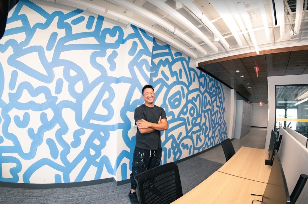mike han poses in front of blue line mural at linkedin detroit, copyright by ipaintmymind